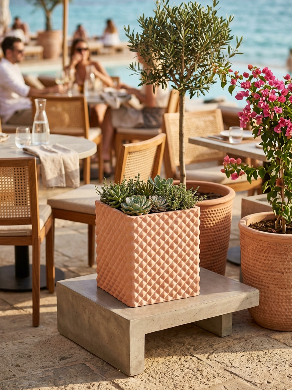 Vaso cubico in terracotta rosa con decoro a losanghe e succulente su base in cemento